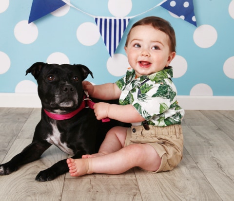 Sitting child with pet dog by Jayne Poole