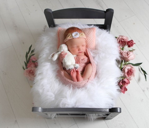 Newborn girl in a crib snuggling a rabbit surrounded by a fluffy white blanket by Jayne Poole Photography, North Devon, Bideford, Torrington, Barnstaple, South West, Devon North.
